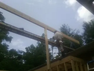 Carpenter setting a ridge beam over a new addition frame — Ice Dam Removal by Roofing Brothers in Shreve