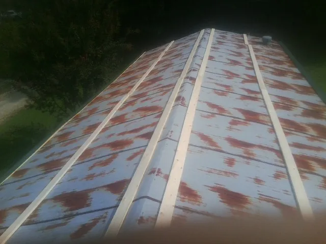 Rusted metal roof panels with new wood purlins before replacement — Storm Damage Roof Repair in Shreve by Roofing Brothers