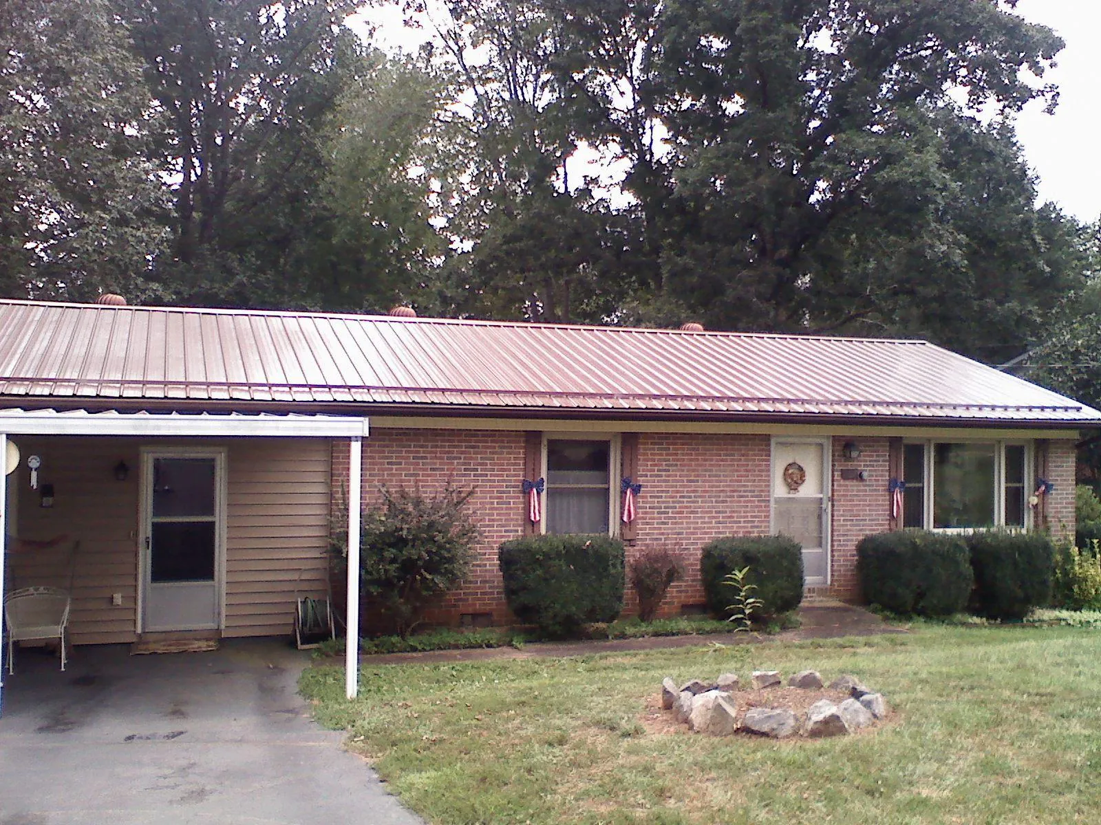 Bronze metal roof and carport on a brick ranch home — Roof Repair work by our crew in Shreve