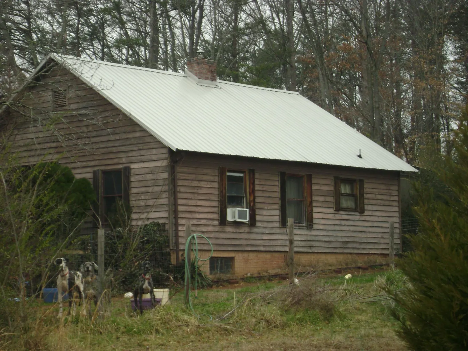 White metal roof on an old wood sided farmhouse, from a Metal Roof Installation job in Shreve